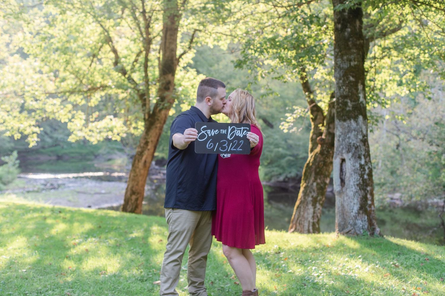 Romantic outdoor engagement photos captured in a sun-dappled wooded setting.