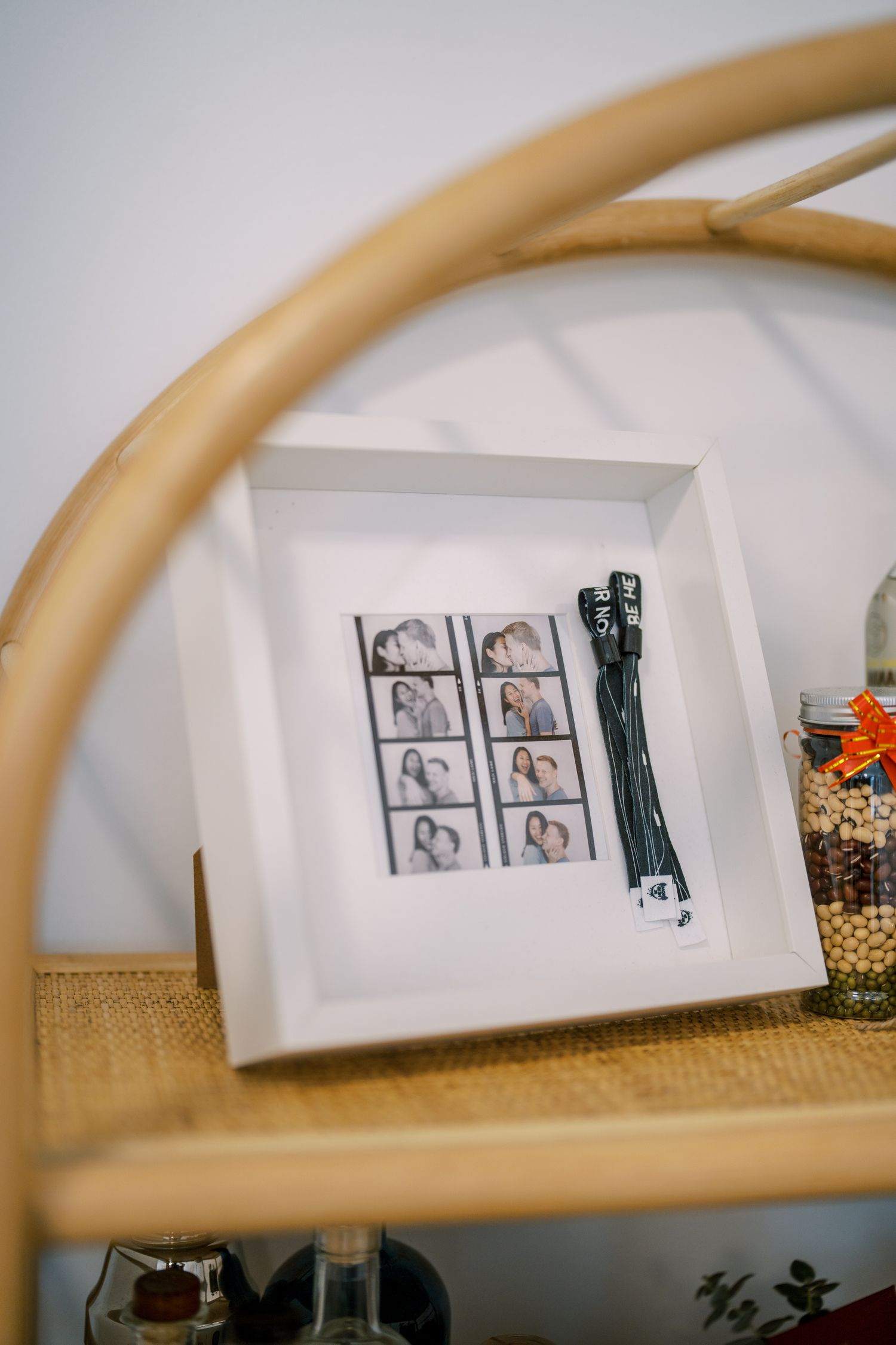 Black and white photographs displayed on a shelf viewed through a curved frame.
