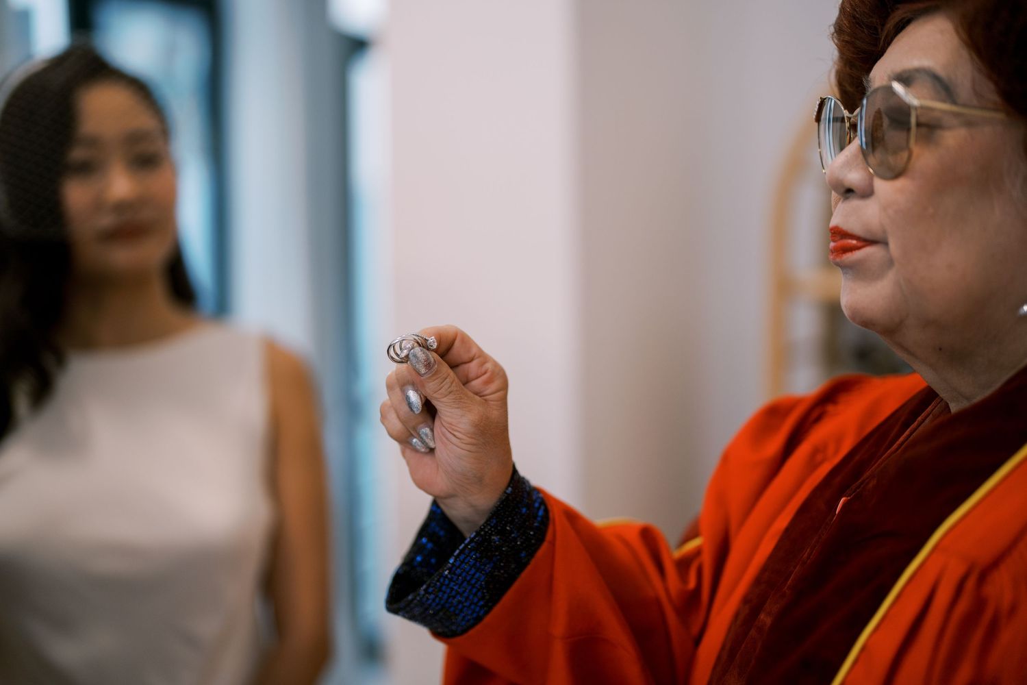 People in formal attire gathered in a bright indoor space during a ceremony.