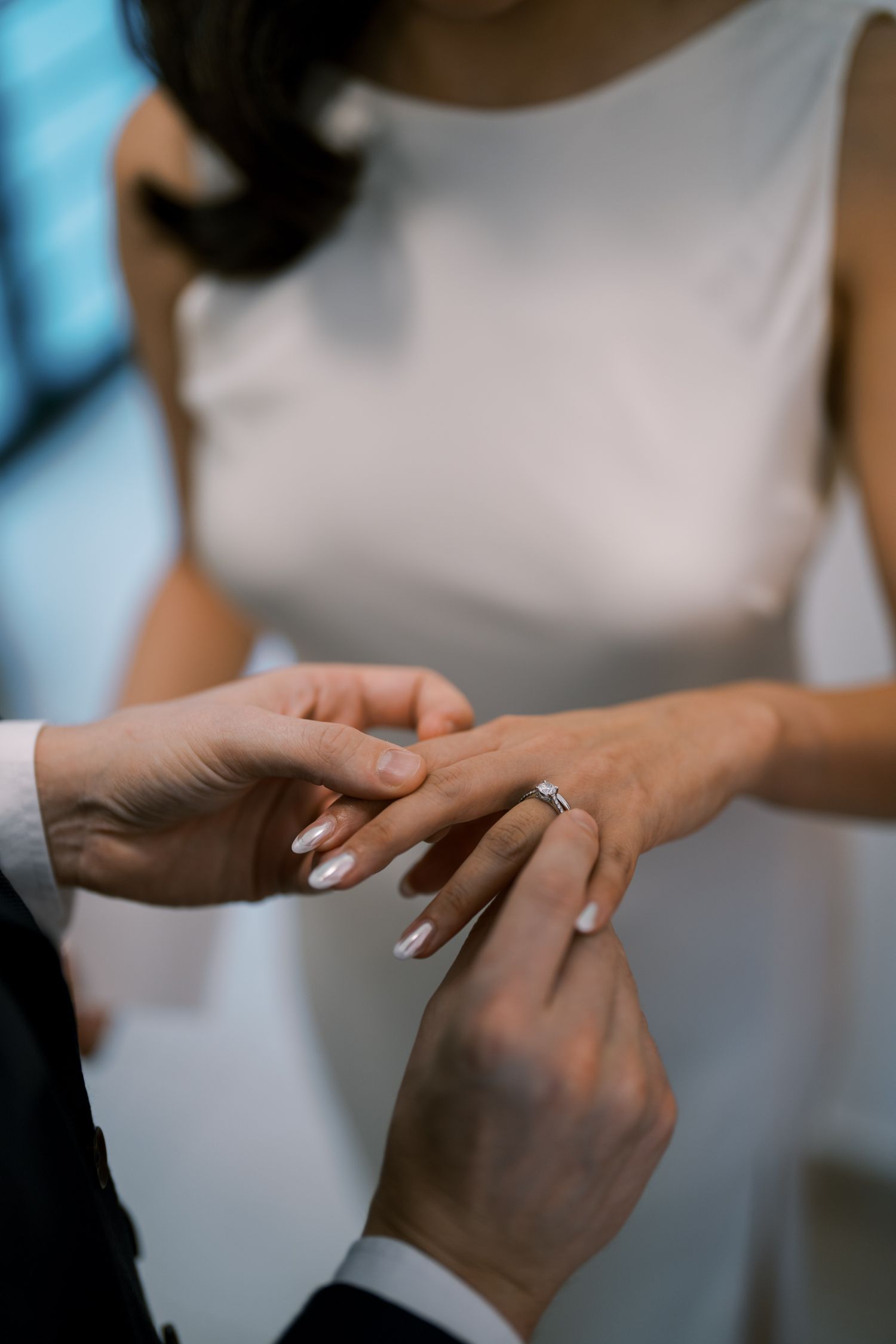 Close-up of hands exchanging rings during an intimate wedding ceremony.