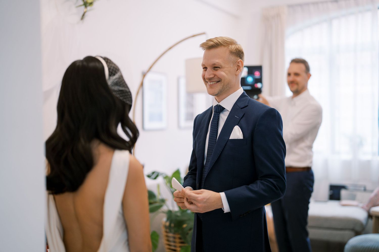 A couple interacting during a wedding ceremony in a bright, modern indoor space.