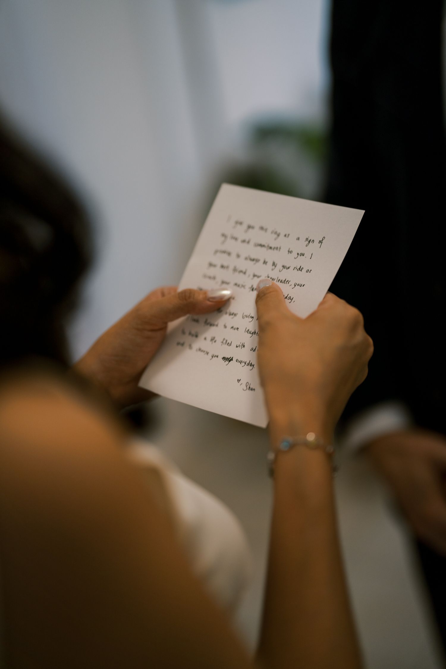 Hands holding a handwritten note or vows during a wedding ceremony.