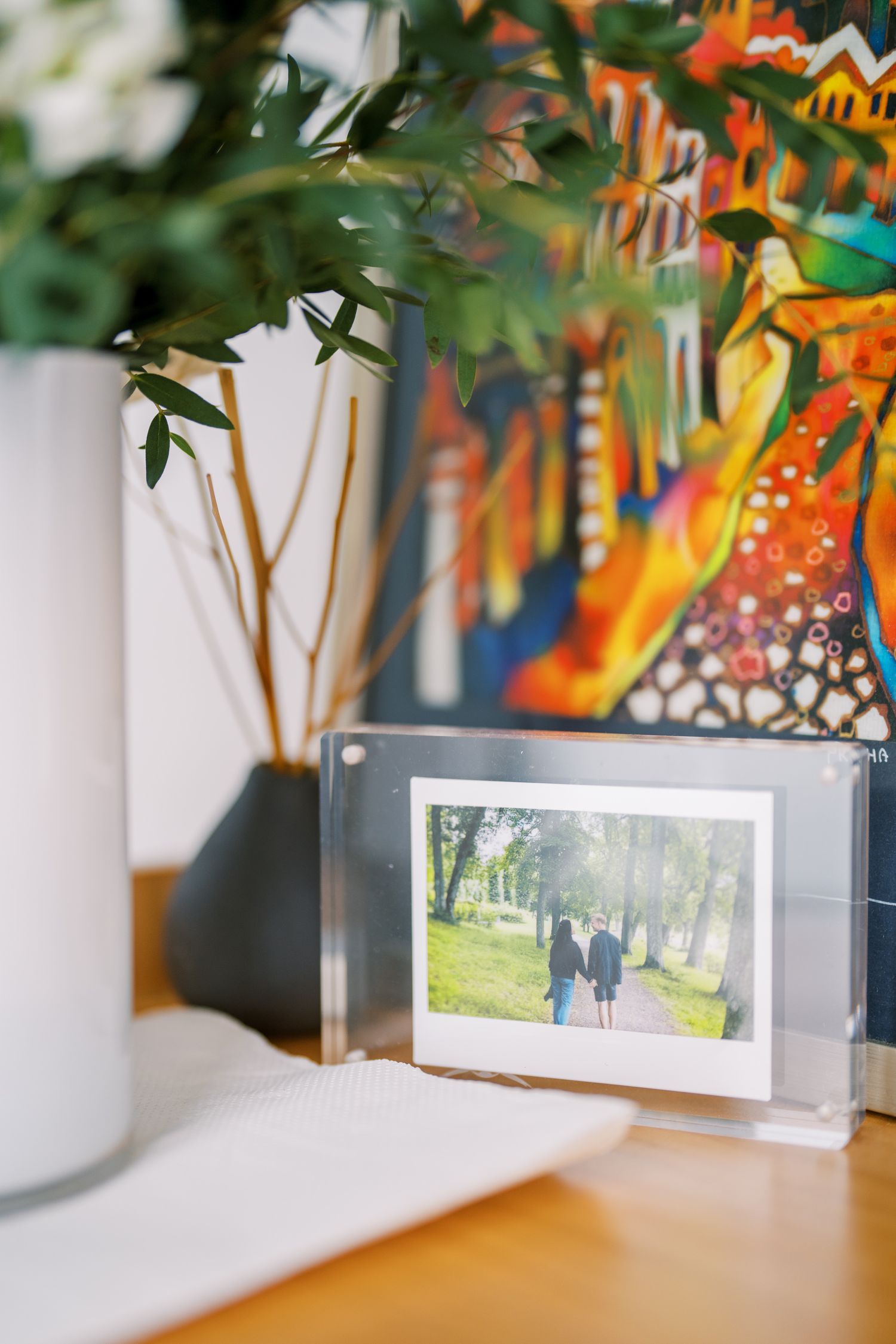 Orange flowers and framed photographs displayed on a white surface with natural lighting.