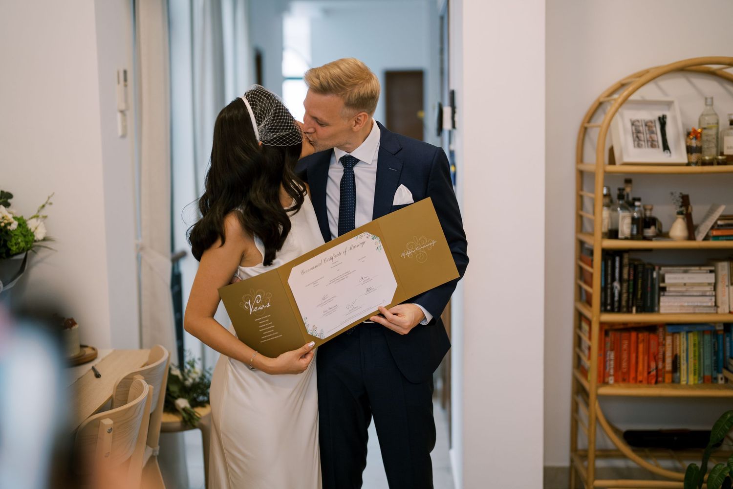 Happy couple sharing a candid moment in a bright indoor space with bookshelves.
