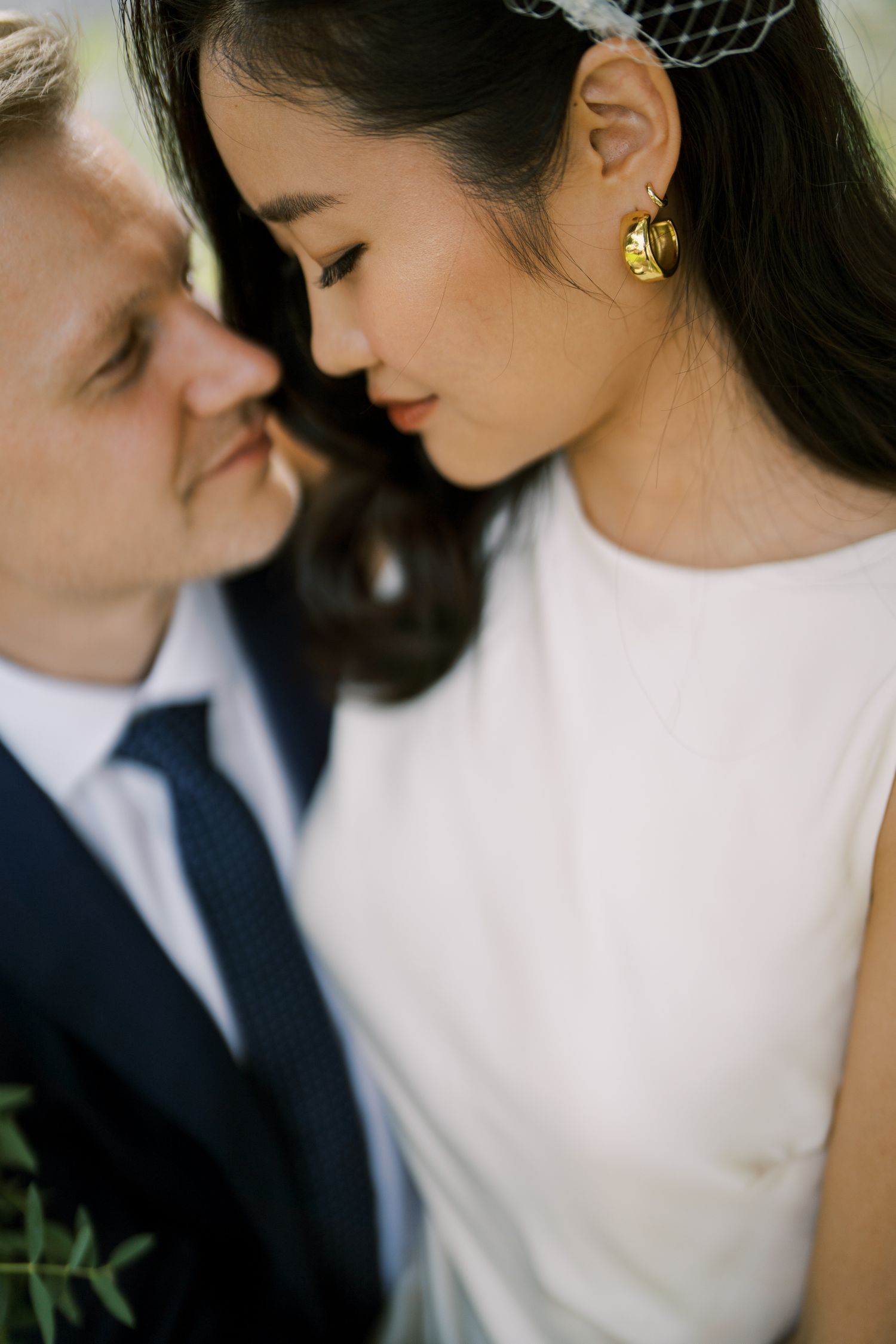 Close-up portrait of a couple sharing an intimate moment in formal attire.