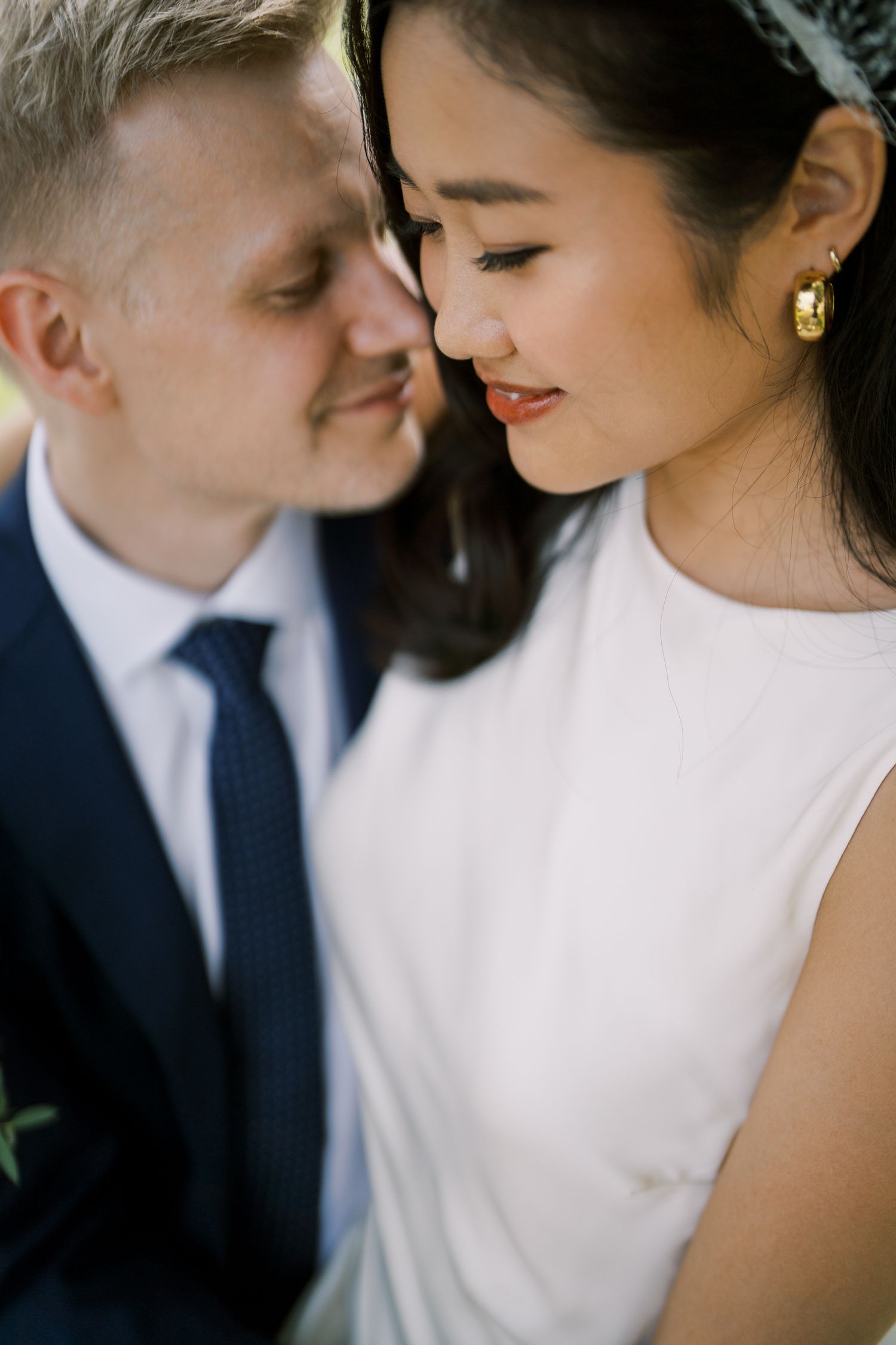 Intimate close-up portrait of a couple in wedding attire with soft natural lighting.