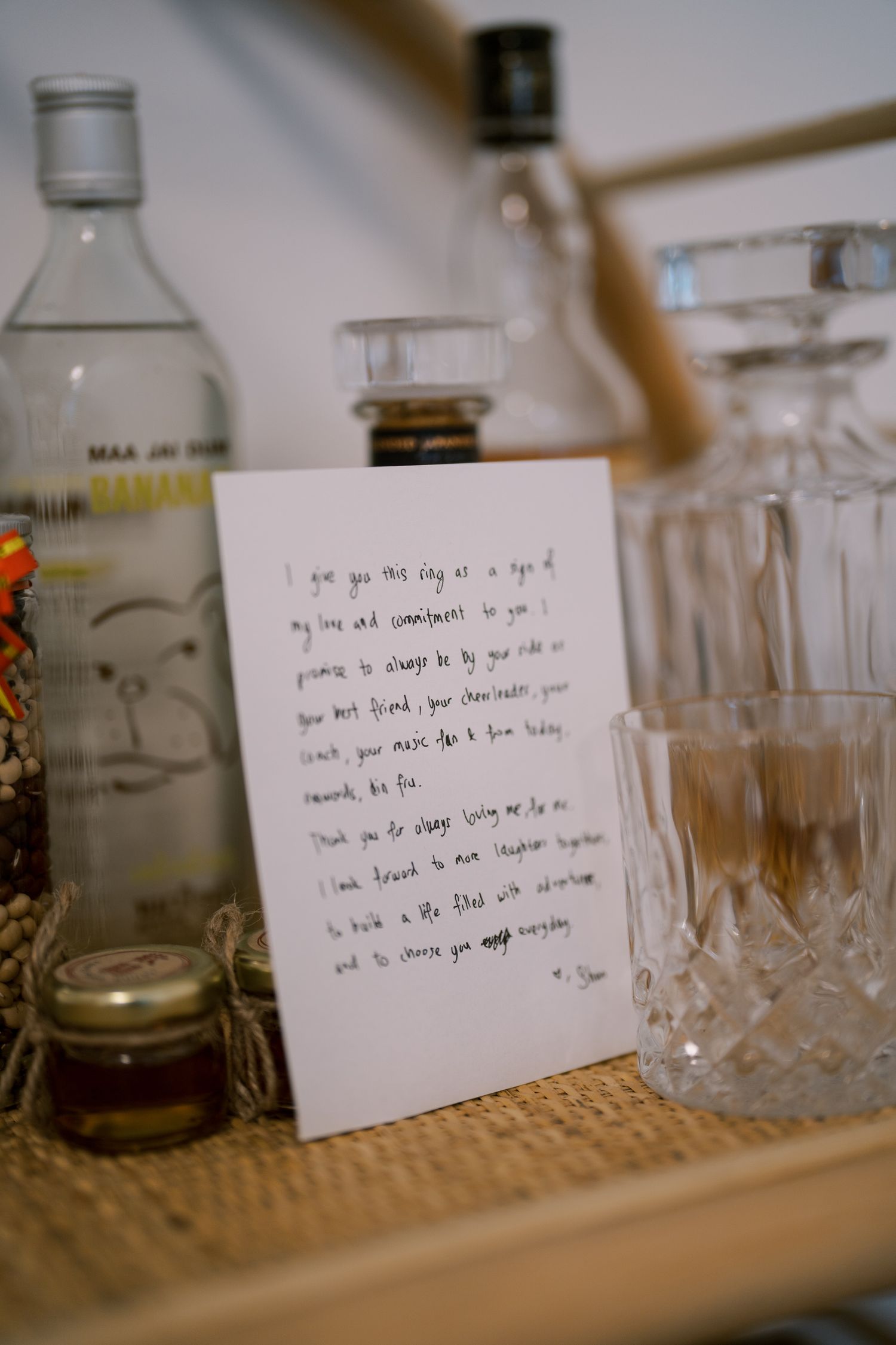 Glass bottles and handwritten notes arranged on a wooden surface in soft focus.