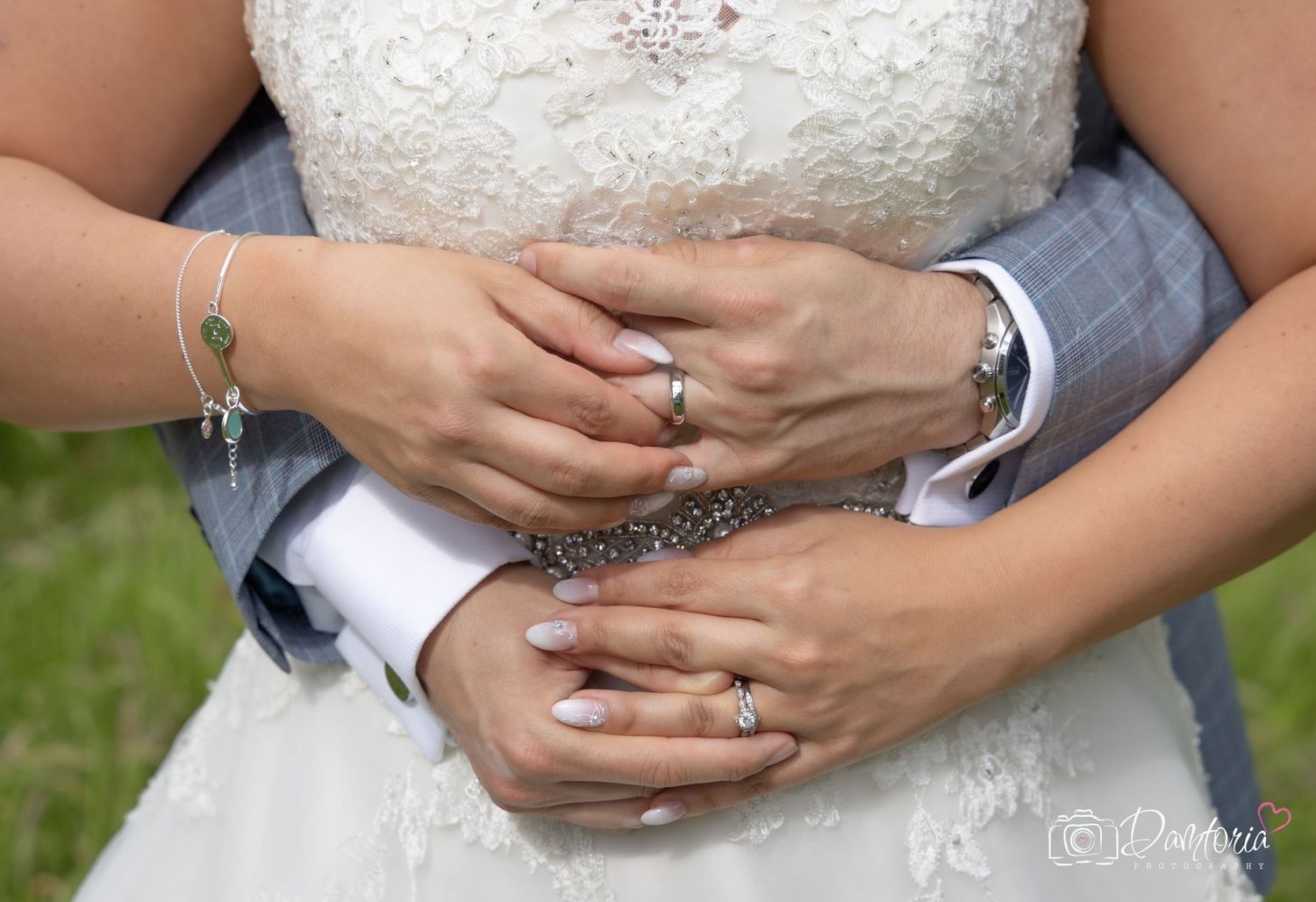 Close up of wedding rings and hands with intricate henna design on the bride's hand.