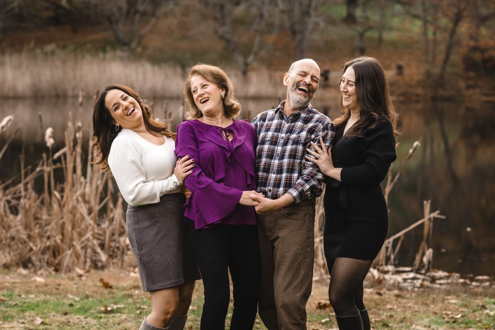 Family members share joyful moments together outdoors during a fall photoshoot.