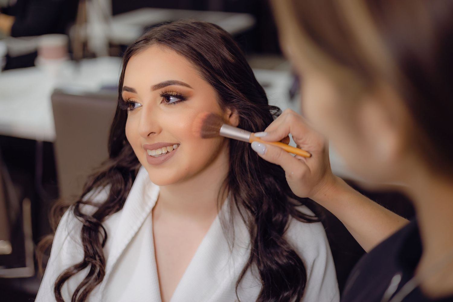 Close-up of makeup being applied during formal event preparation.