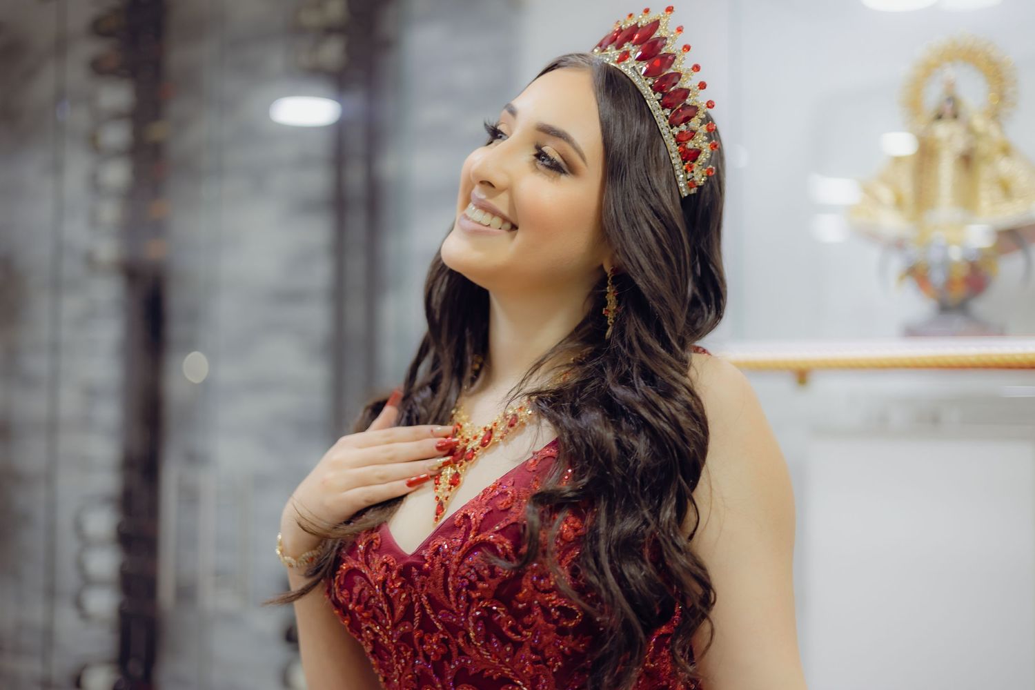 Elegant formal attire featuring a red crown and sparkling dress.