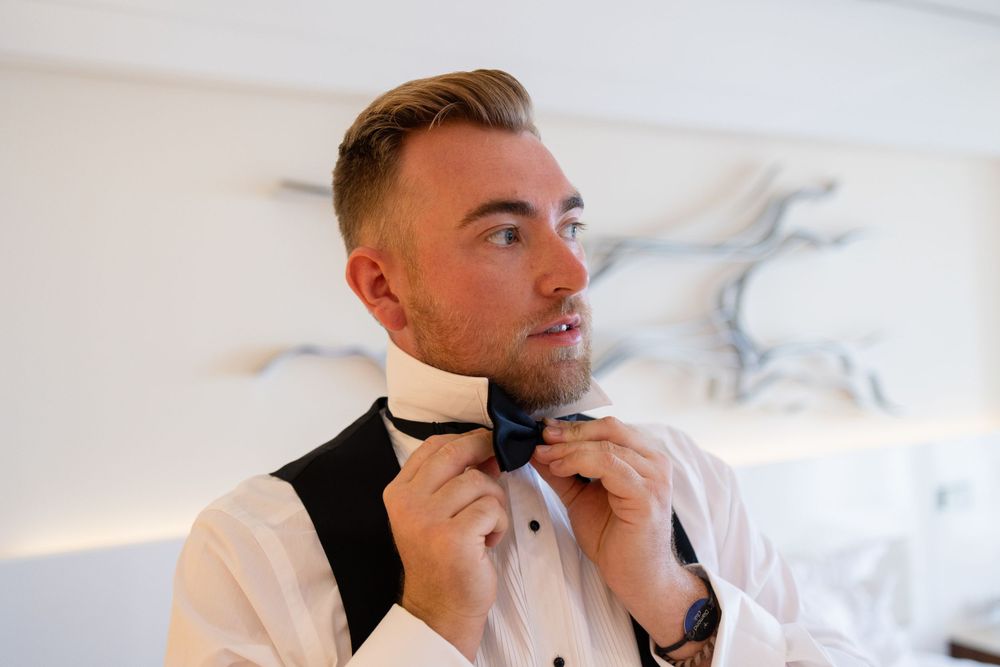 Groom adjusting bow tie