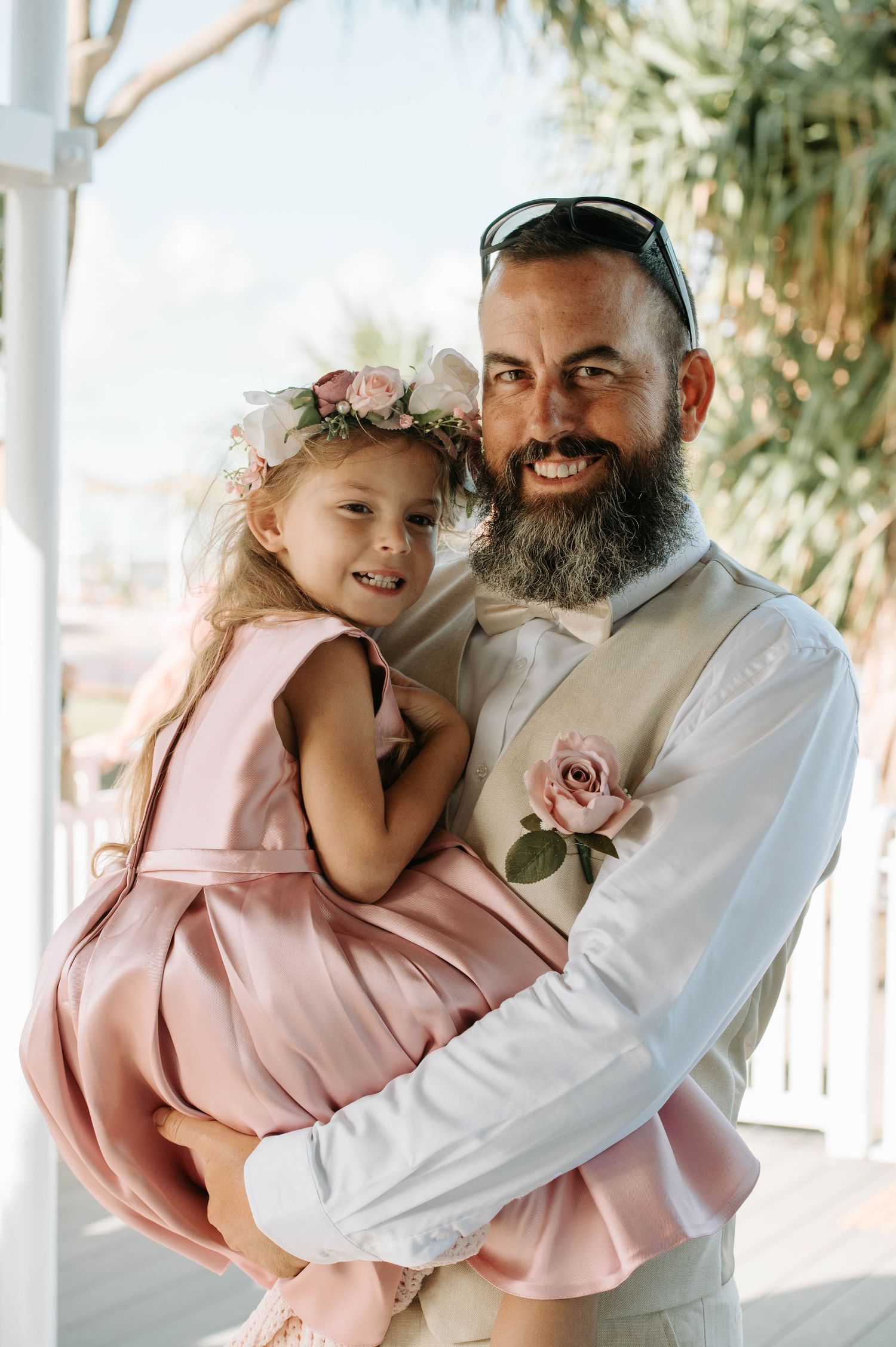 Sweet moment between father and daughter in pink dress at wedding celebration.