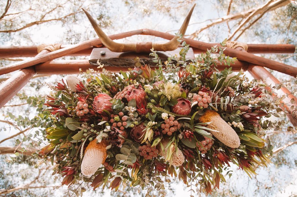 Beautiful hanging floral arrangement with pink and cream native flowers and greenery.
