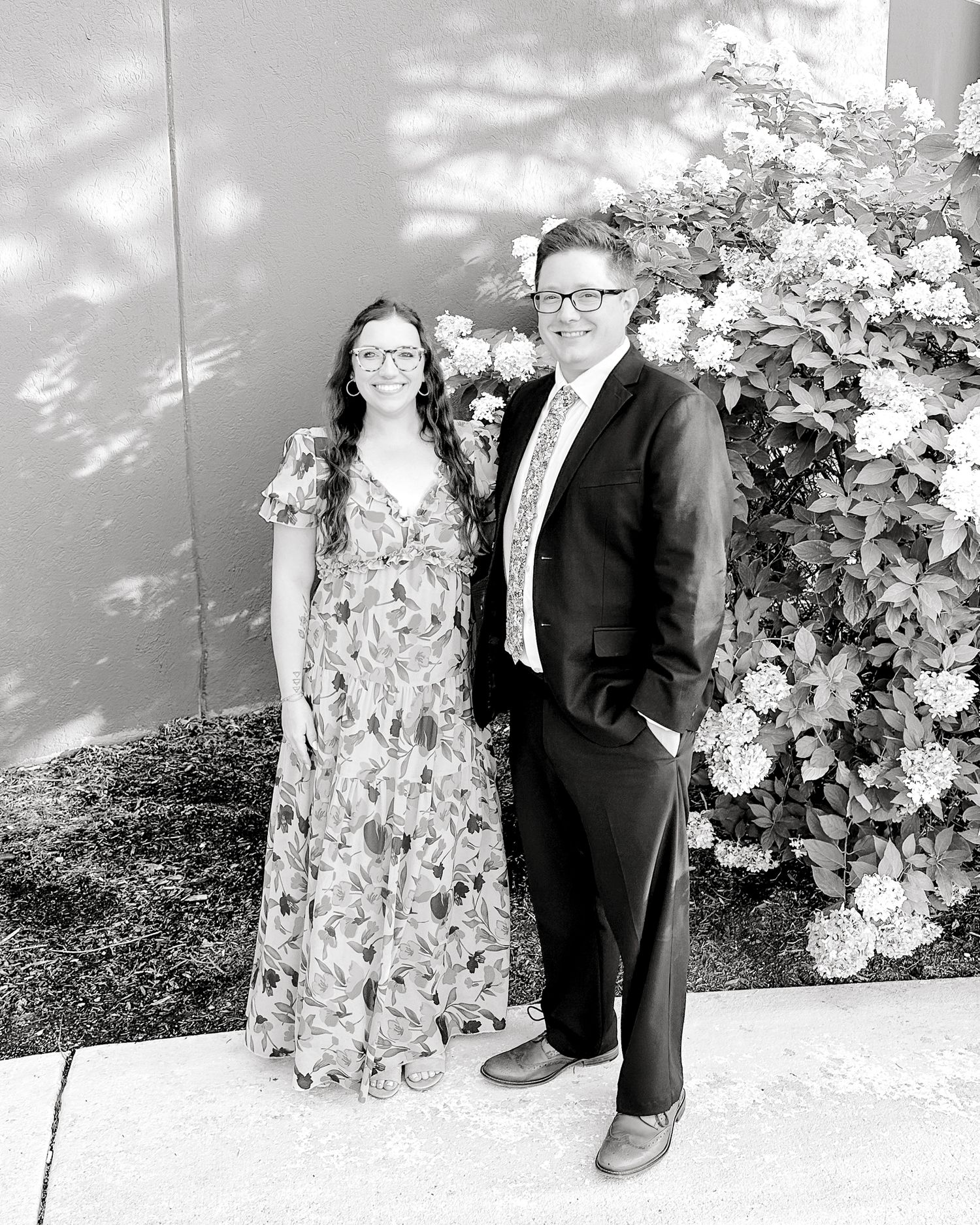 husband and wife standing together, smiling for the camera