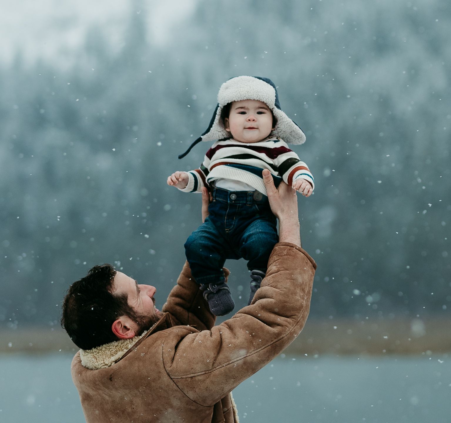 Dad holding baby up high