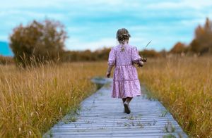Young girl walking down a boardwalk