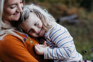 Young daughter cradled in her mother's arms