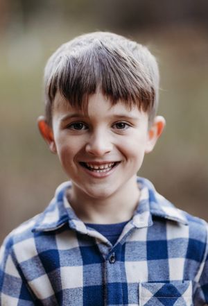 Young boy smiles goofishly at the camera