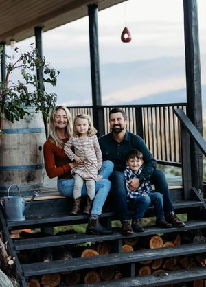 Family sitting on the steps to their porch