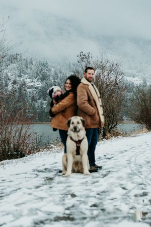 A family and their dog in the snow