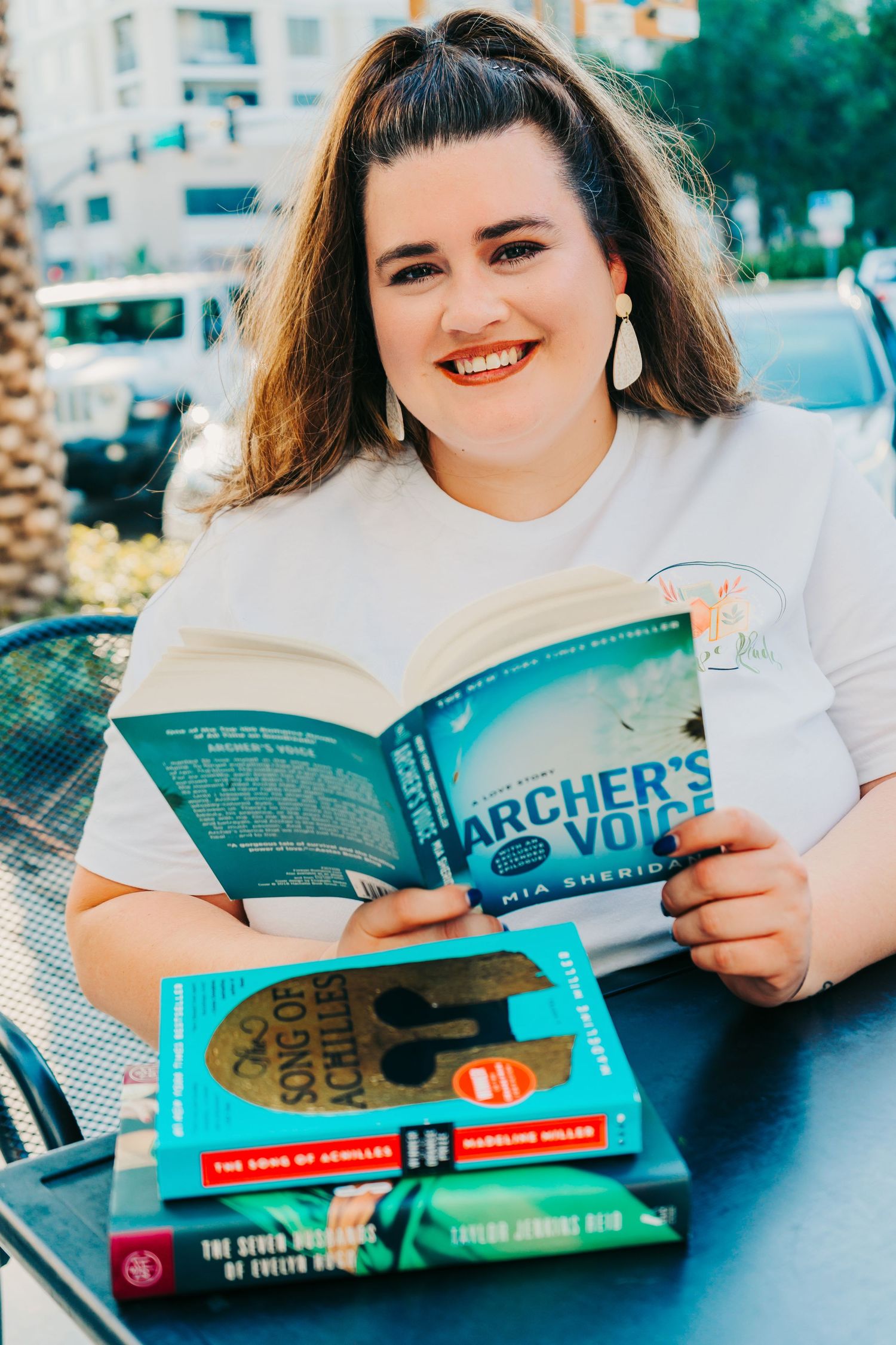 Headshot photo in Downtown St. Pete in Pinellas County - woman smiling with pile of books