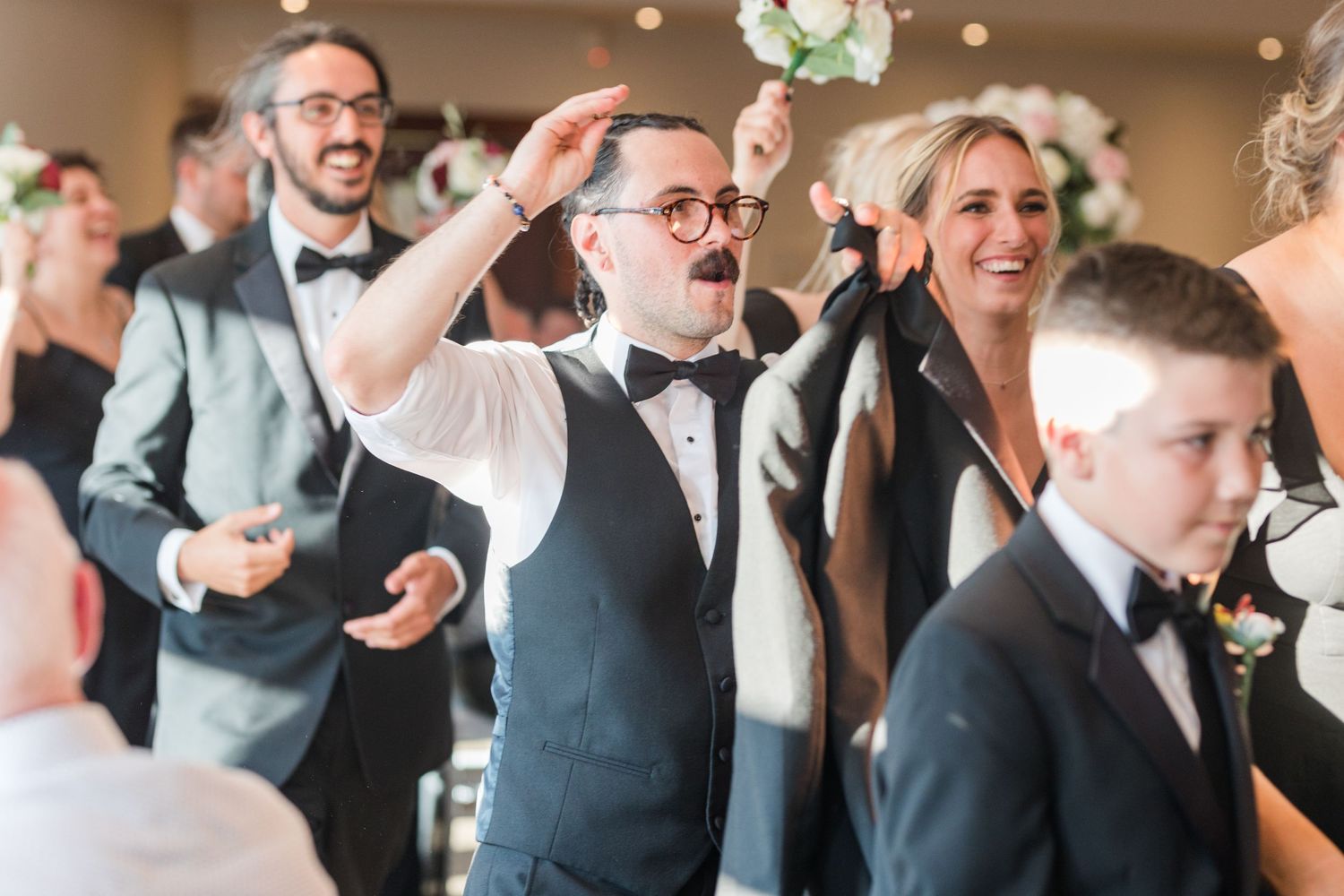 Candid moment of wedding guests celebrating and dancing during reception.