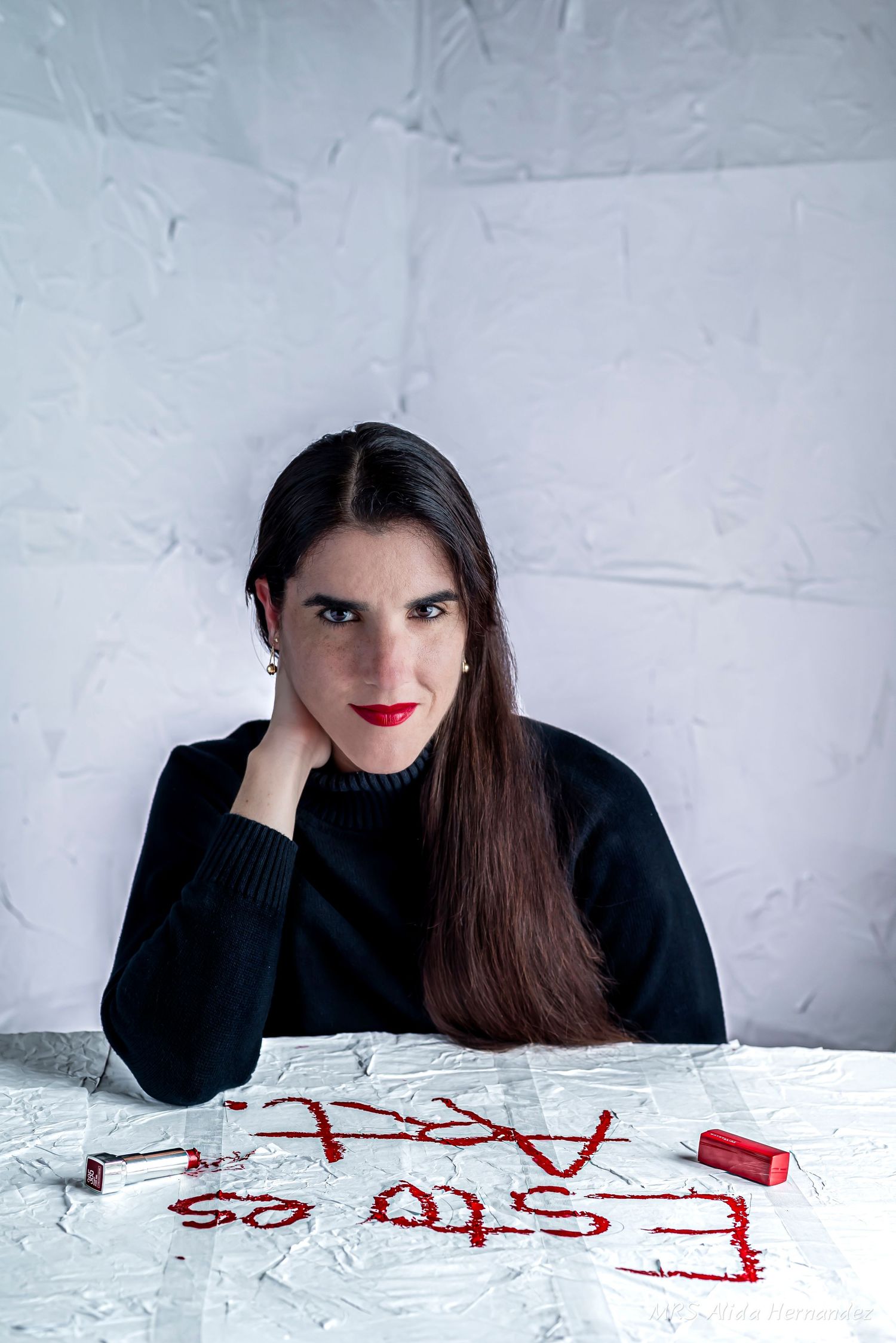 Alida Hernandez is a cuban photographer. Alida is wearing a black sweater and red lipstick