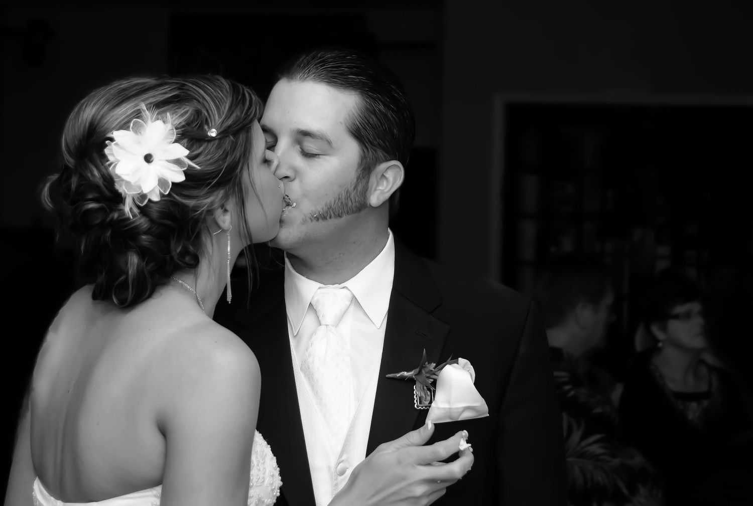 A romantic black and white wedding photograph capturing a tender moment between newlyweds.