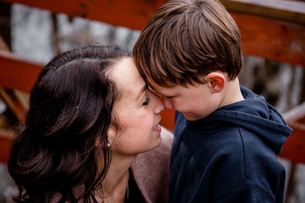 An intimate moment shared between two people on a wooden bridge.