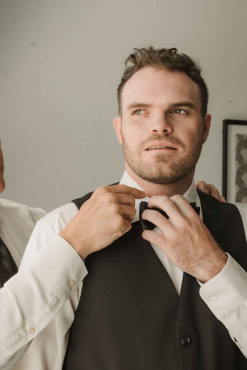 Close-up shots of a groom adjusting his tie and collar before the wedding ceremony.