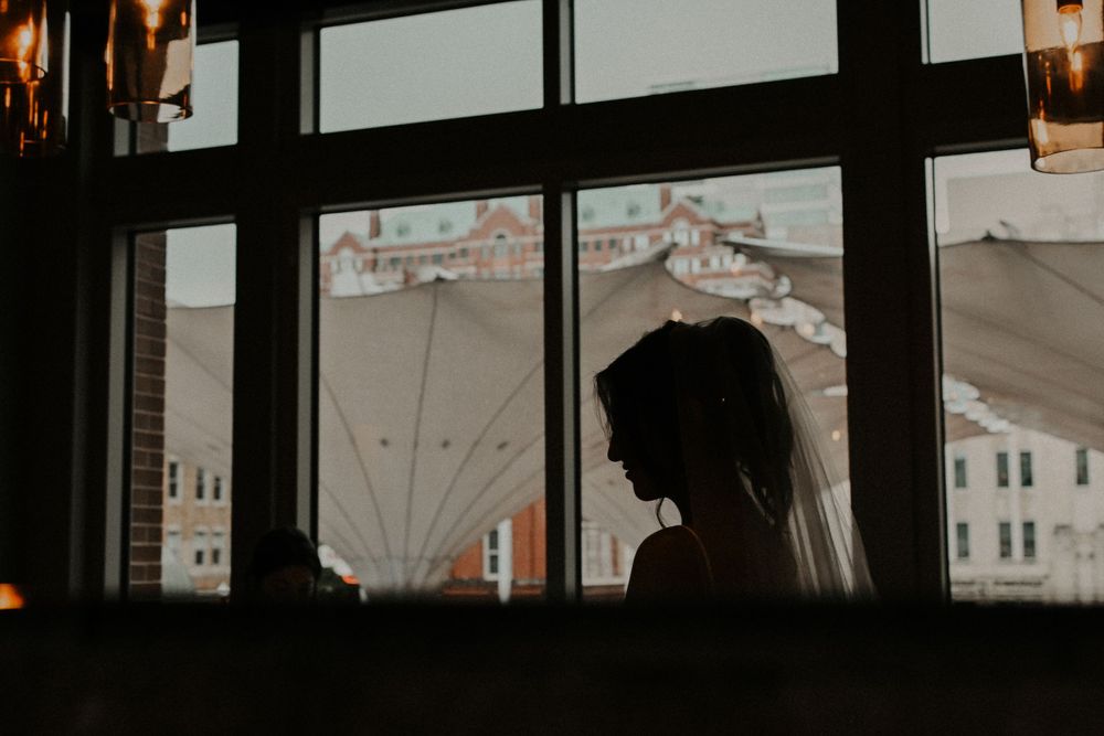 Silhouetted cityscape view through large windows at dusk.