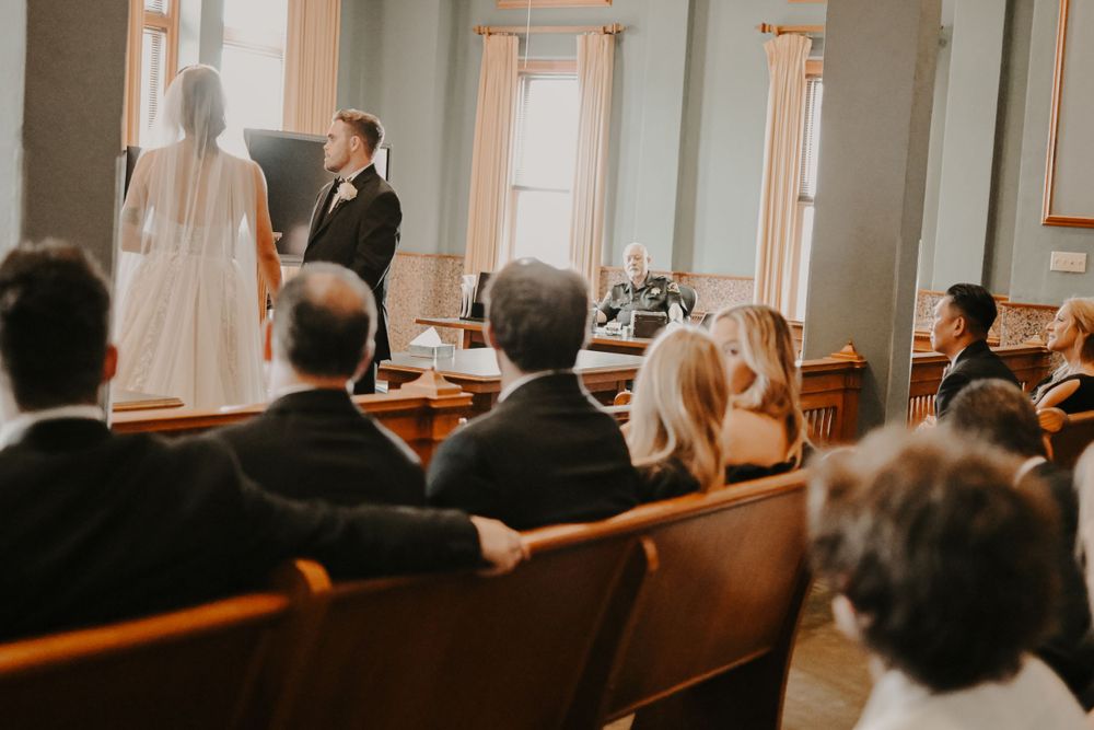 Wedding guests seated in rows at an elegant indoor ceremony venue.