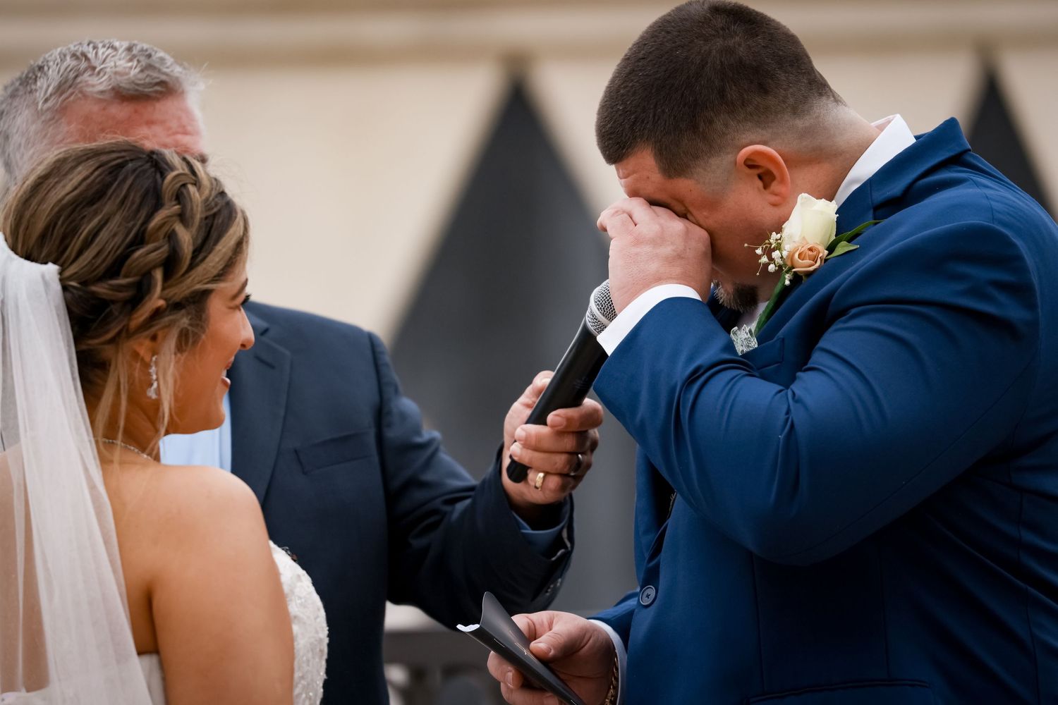 Emotional ceremony moment during wedding vows at indoor venue.
