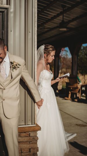A couple holds hands while standing apart in a first look moment before their wedding ceremony.