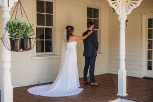 A series of first look wedding photos on a white porch with a bride in a flowing white dress.