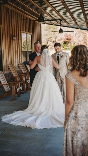 A wedding ceremony moment captured on a covered porch with wooden details and rustic decor.