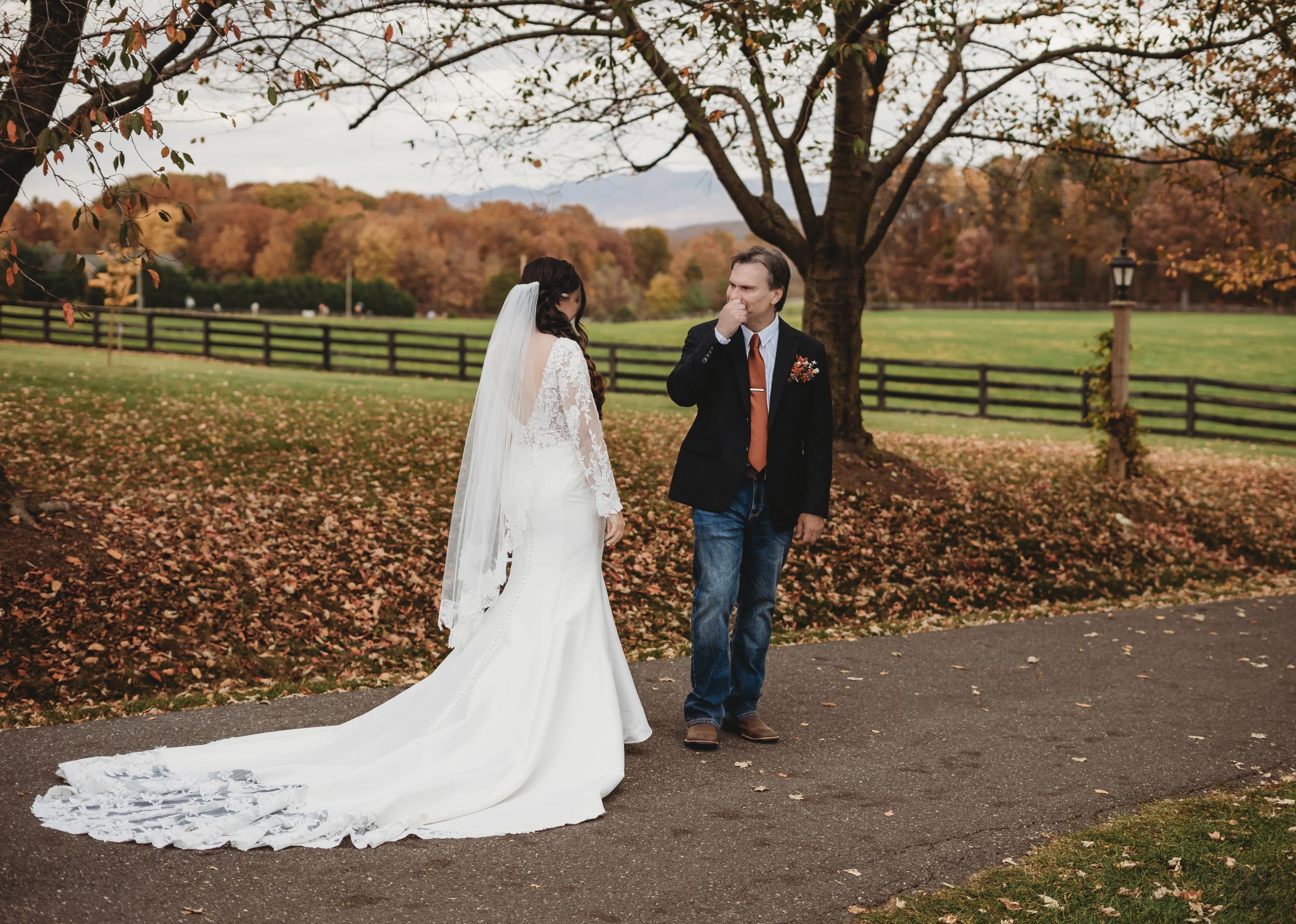 Autumn wedding photos with colorful trees and fallen leaves in the background.