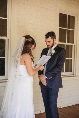 Candid reactions during a wedding first look on a rustic porch.