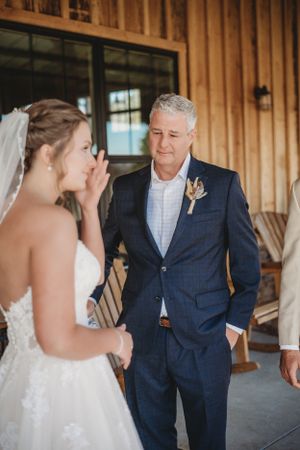 An emotional moment shared between wedding participants on a rustic wooden porch.