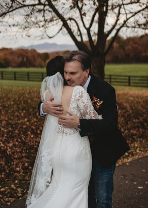 Intimate wedding moment captured on a path surrounded by fall colors.