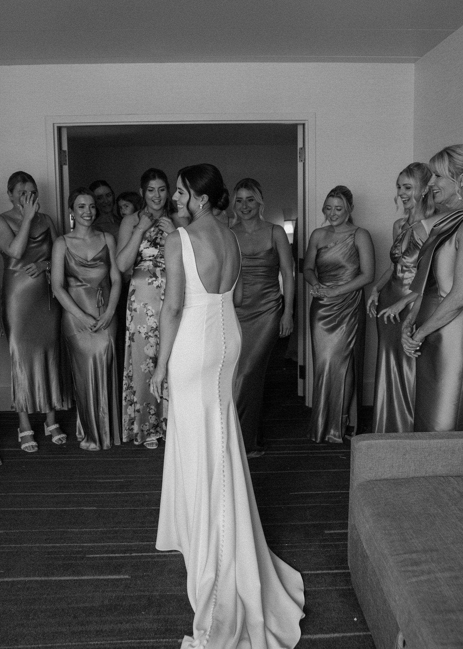 Wedding party gathered on stairs watching emotional first look reveal.