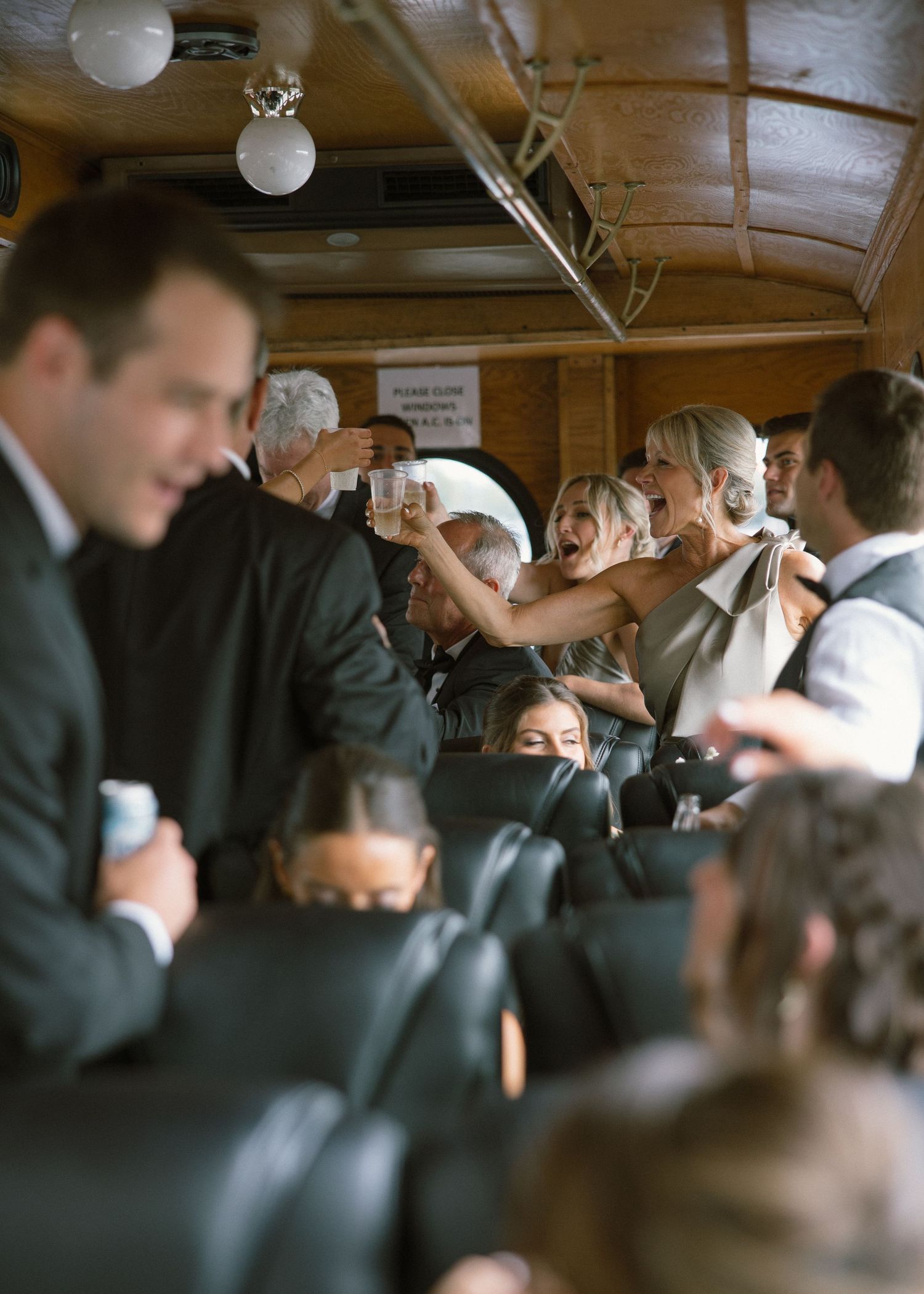 Wedding guests celebrate and dance inside a vintage trolley car during a joyful reception.