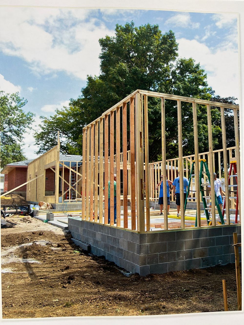 Construction progress showing wooden frame structure being built on concrete foundation.