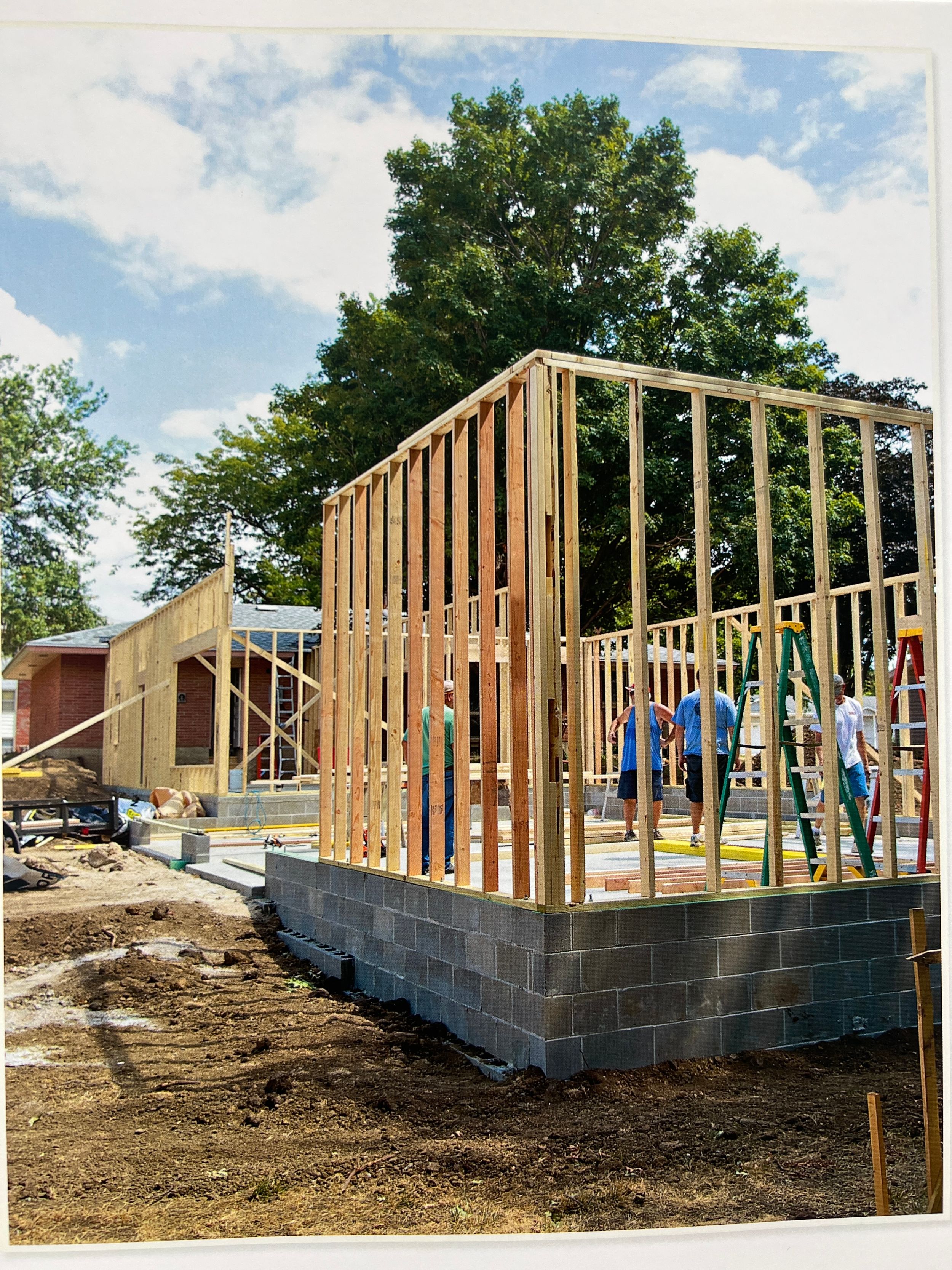 Construction progress showing wooden frame structure being built on concrete foundation.
