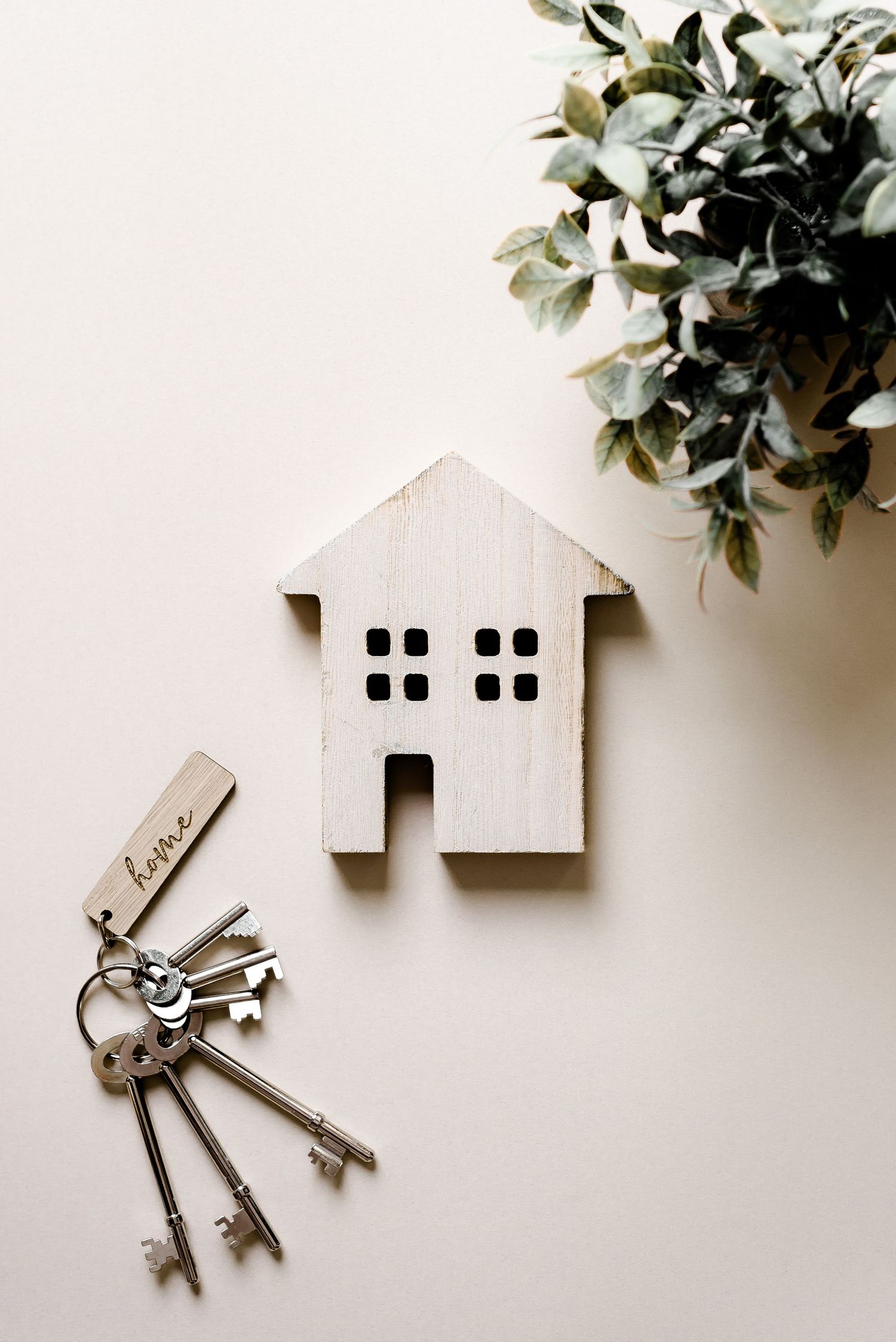 Small wooden house with keys and a 'home' keyring. Moving house, new home, packing, unpacking