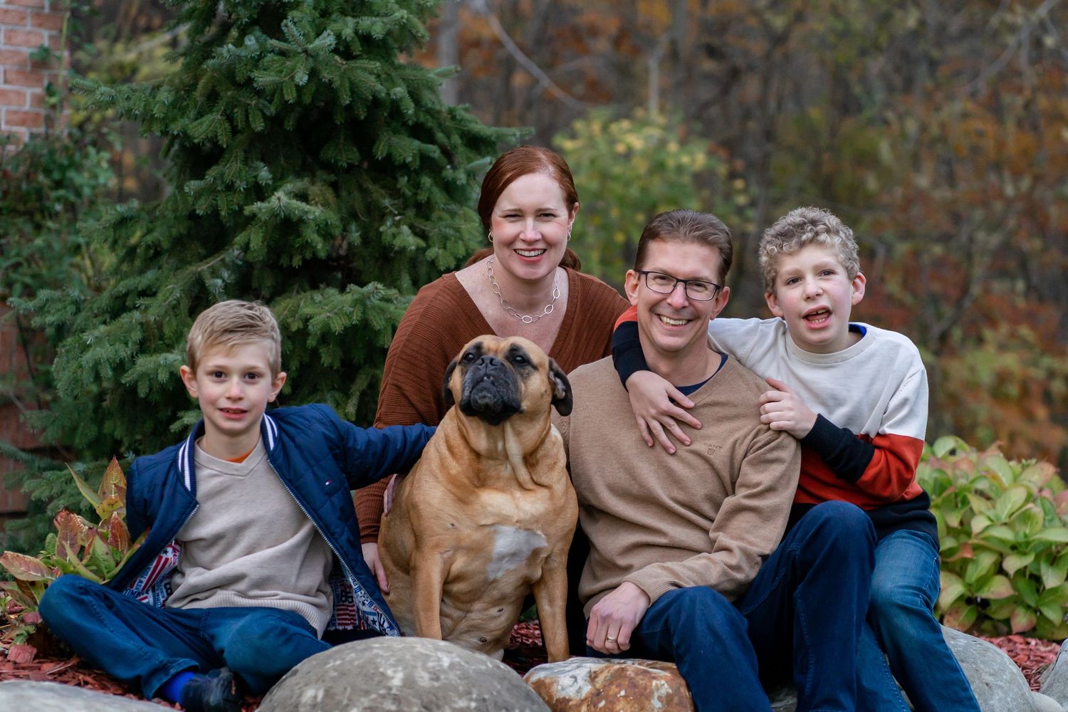 Family of four loves on their sweet dog at their family home in Clarkston, MI