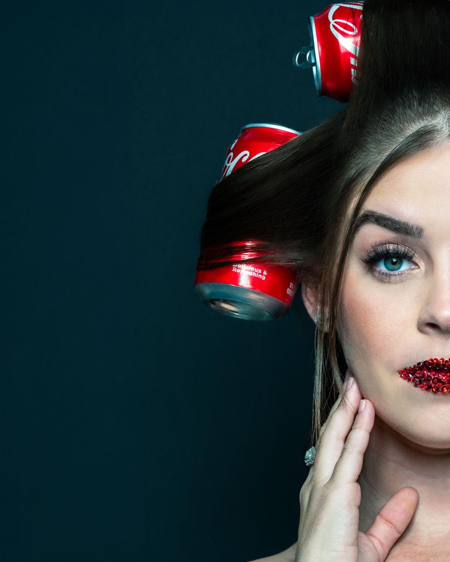Creative beauty portrait with Coca-Cola cans as hair rollers and glittery red lips.