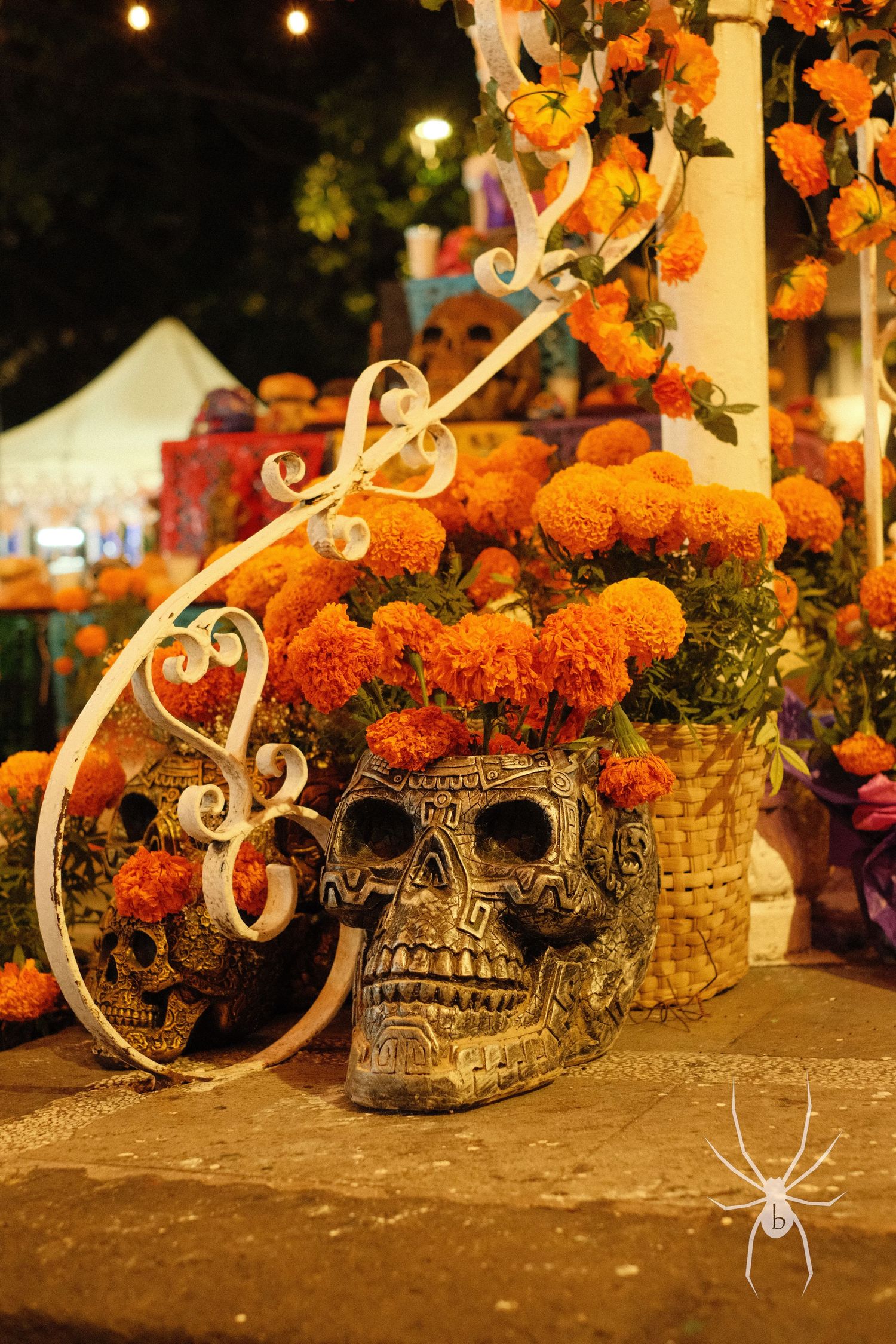 Traditional Day of the Dead altar decorated with orange marigolds and an ornate sugar skull.