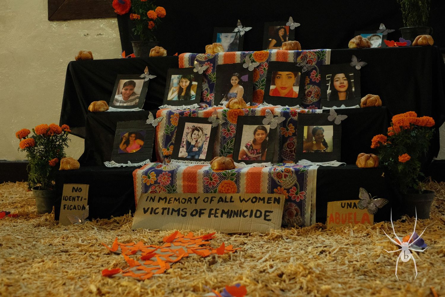 Memorial display with photographs and marigolds honoring victims of femicide.